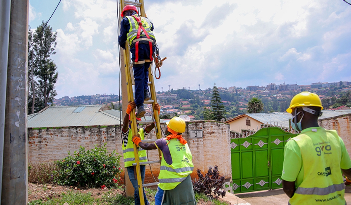 CanalBox Rwanda technicians install aerial fiber optic cables in a Kigali neighbourhood in June, 2022. File