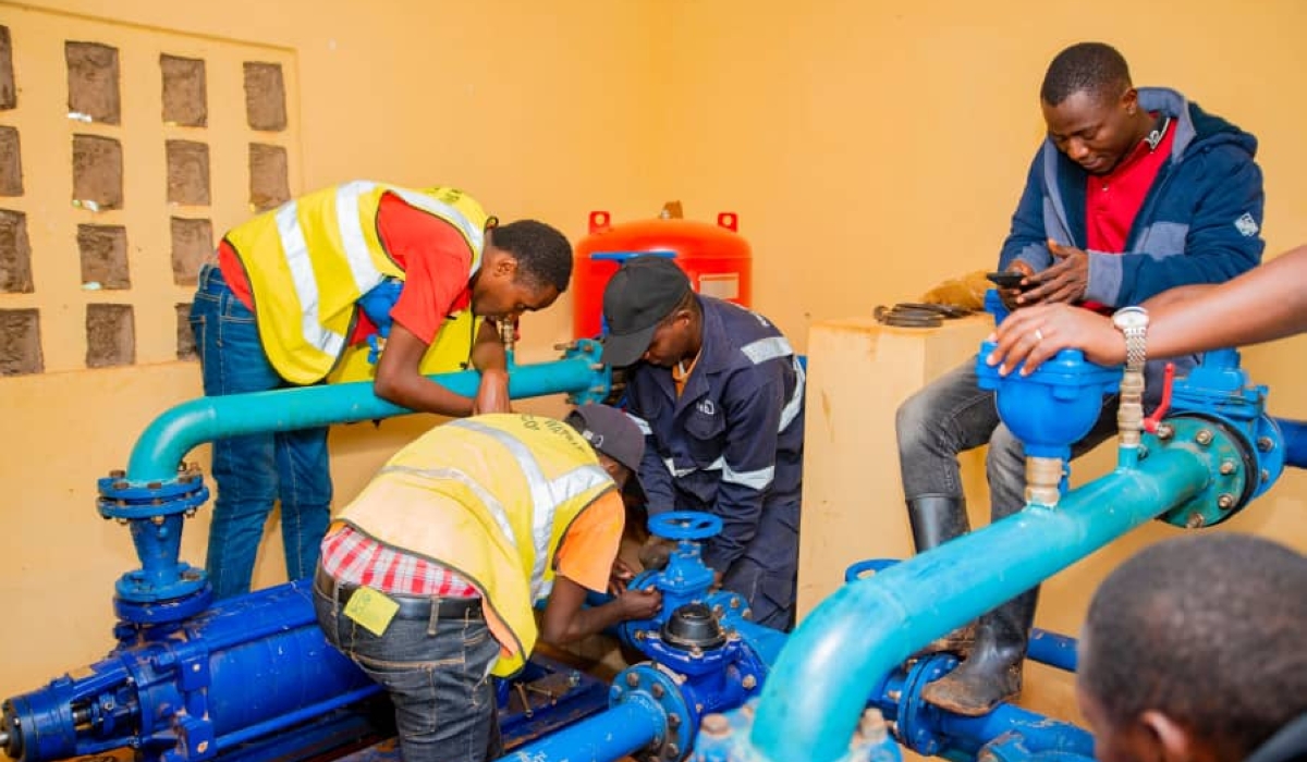 Technicians fix  water pump at  a water supply project in Rwanda.  The project will address the challenge of operation and maintenance of the pumped water systems in Rwanda