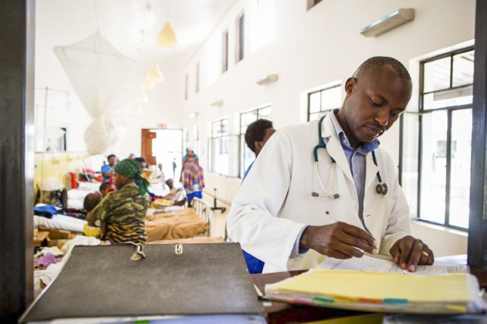 Dr. Cyprien Shyirambere, oncology program director for Partners In Health in Rwanda, records medical information after seeing patients for follow-up visits at PIH-supported Butaro District Hospital.