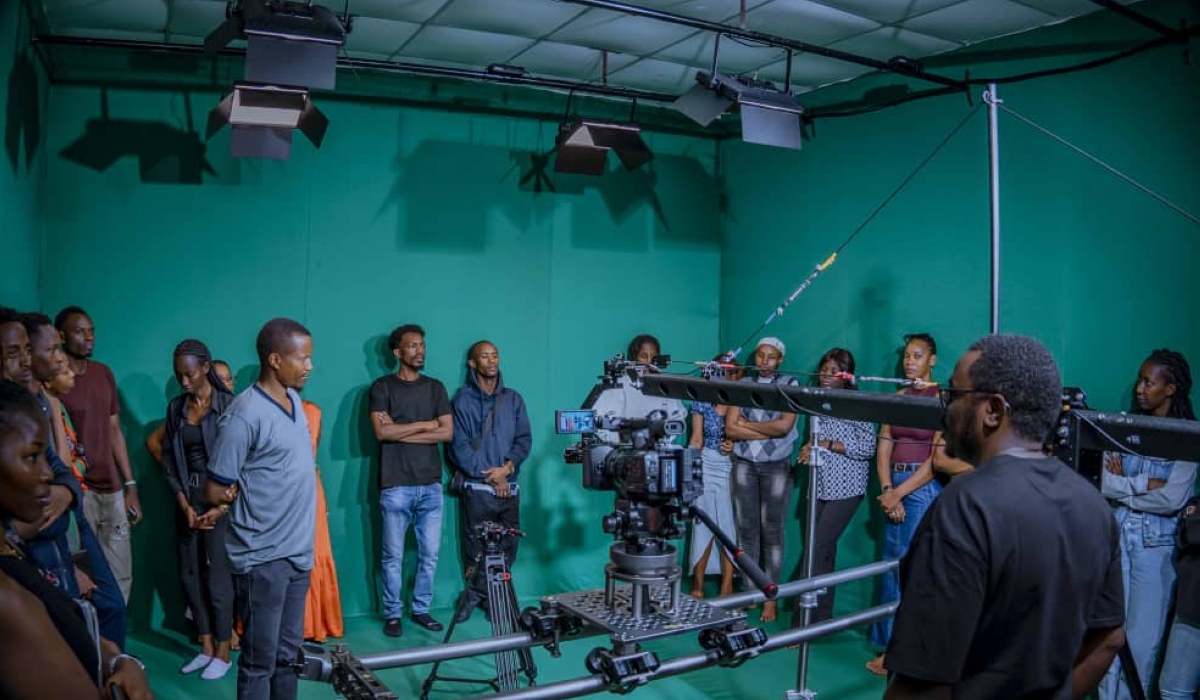 The Head of Department Mr Festus Irungu with students admiring the new equipment being set up in the TV studio.