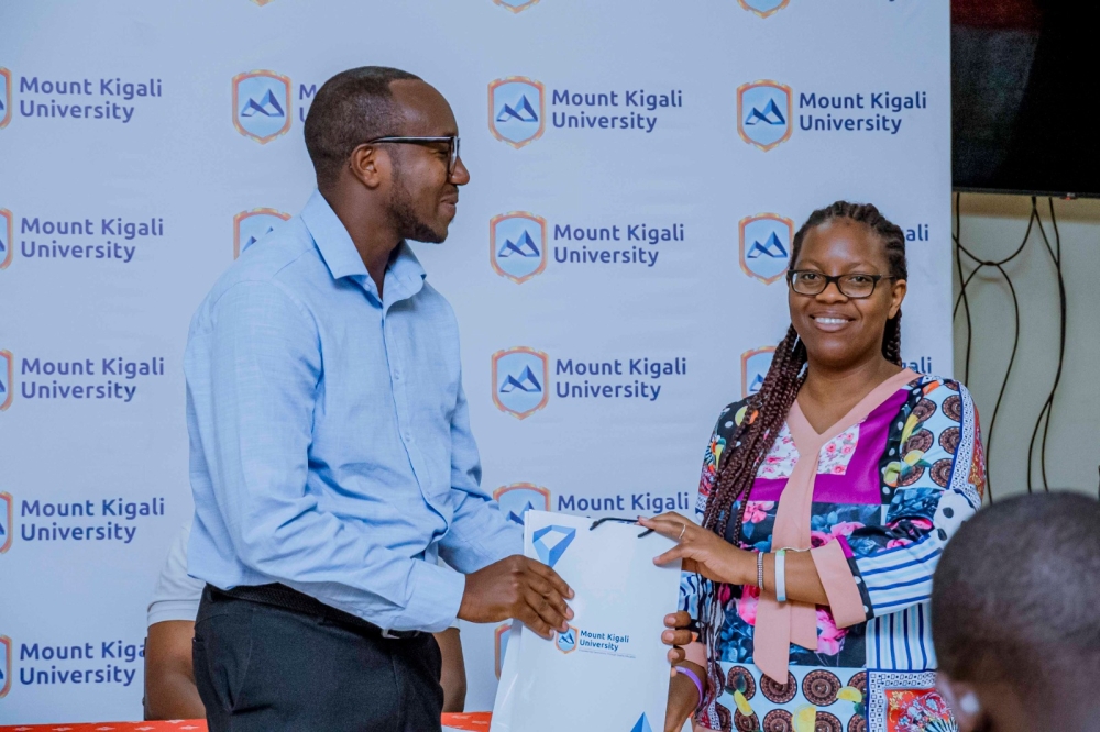 MKU librarian Muthee Lucy Wangechi appreciates a postgraduate student, Jean Mutabazi, for being an active library user.
