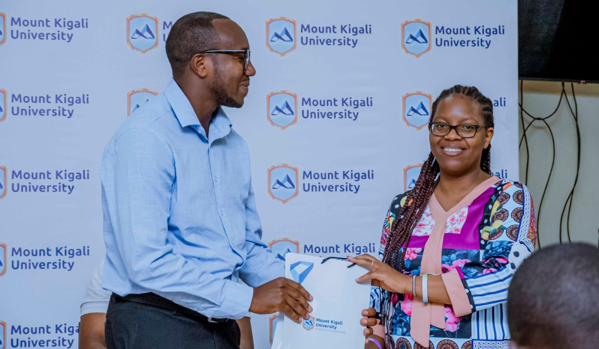 MKU librarian Muthee Lucy Wangechi appreciates a postgraduate student, Jean Mutabazi, for being an active library user.
