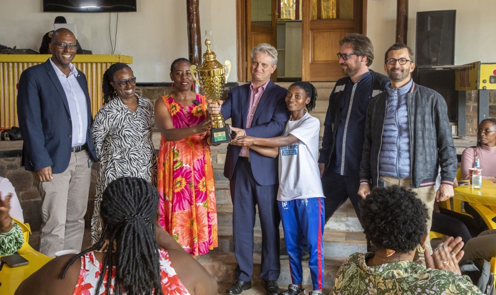 SKOL Brewery Ltd General Manager Eric Gilson (c) and Rayon Sports WFC Dorothee Mukandayisenga pose for the Heroes Cup as the brewer joined the club in celebrating the International Women&#039;s Day-Photos by Craish Bahizi