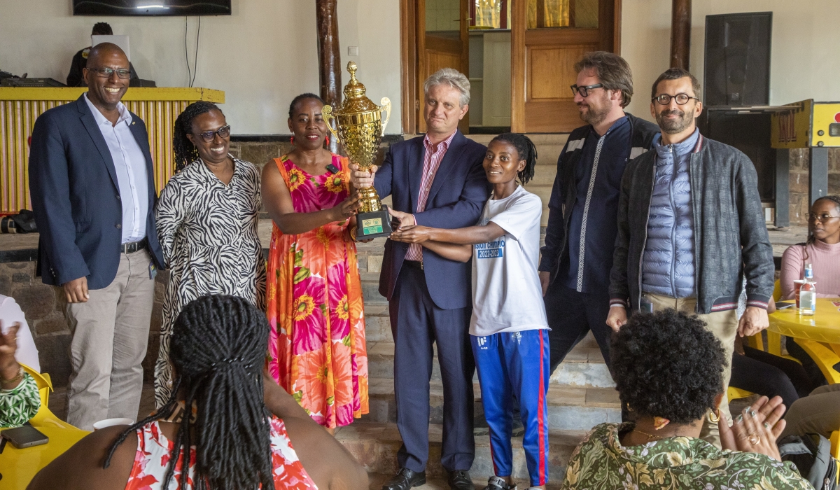 SKOL Brewery Ltd General Manager Eric Gilson (c) and Rayon Sports WFC Dorothee Mukandayisenga pose for the Heroes Cup as the brewer joined the club in celebrating the International Women&#039;s Day-Photos by Craish Bahizi