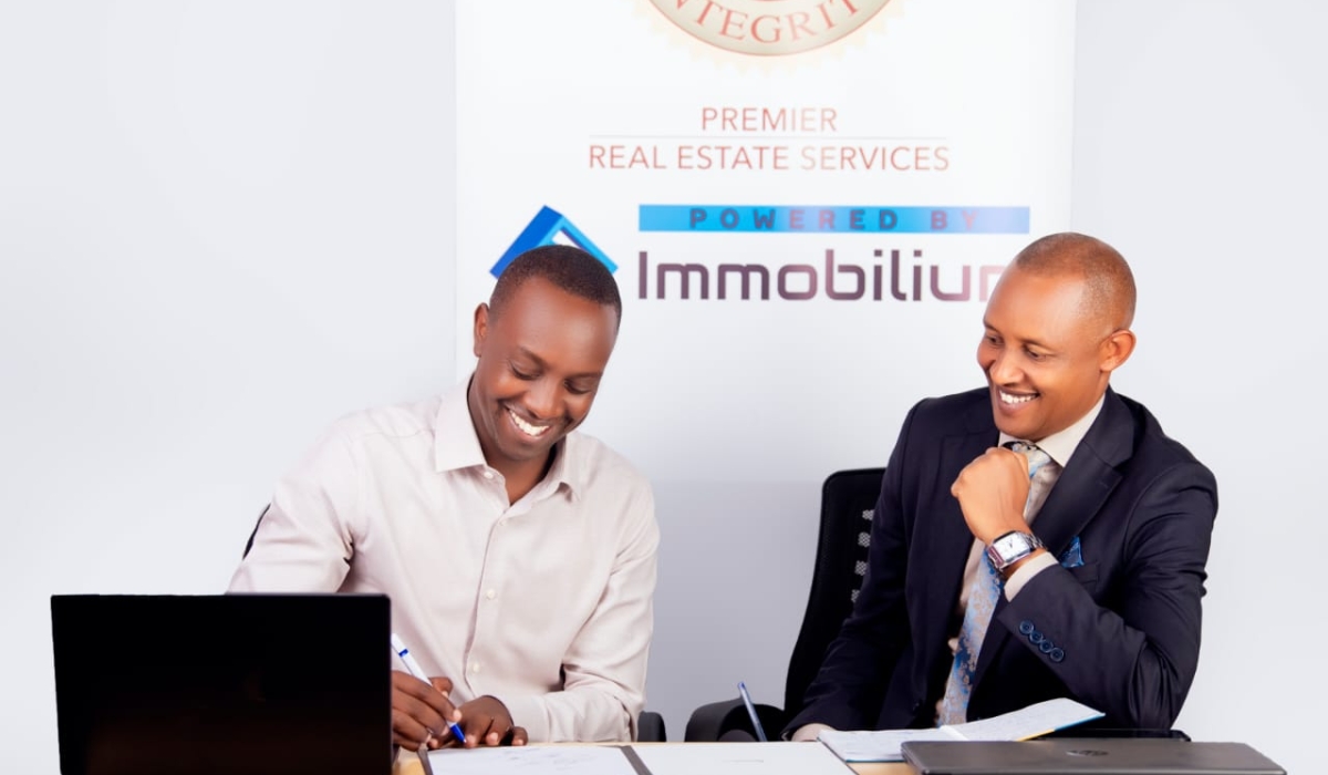 Celestine Uwineza- Managing Director of Premier Real Estate Services (L), and Fred Agaba Operations Manager at Premier Real Estate Services sign the  partnership agreement in Kigali. Courtesy