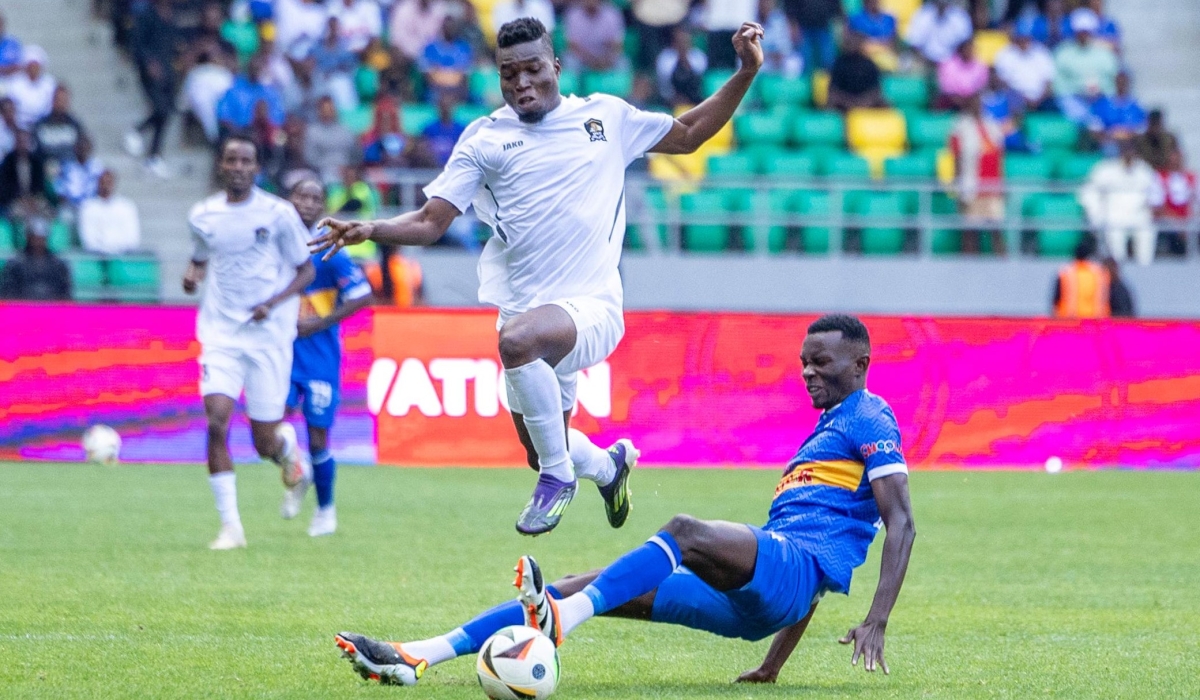 APR forward Djibril Ouattara jumps to avoid a sliding tackle from Rayon Sports defender Omar Gning during a 2-0 final at Amahoro Stadium. Photo by Olivier Mugwiza