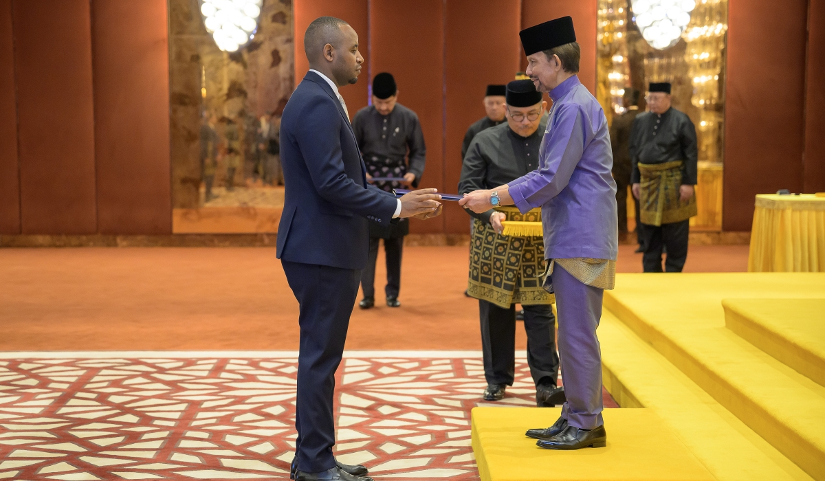Uwihanganye (L) presents his letters on credence to the Sultan of Brunei. Courtesy