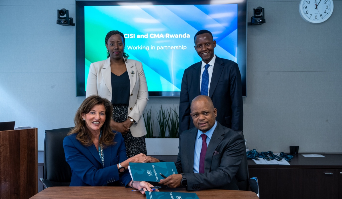 The Chartered Institute for Securities and Investment CEO Tracy Vegro OBE and the Capital Market Authority of Rwanda Chief Executive Thapelo Tsheole exchange documents during the signing ceremony in Kigali.