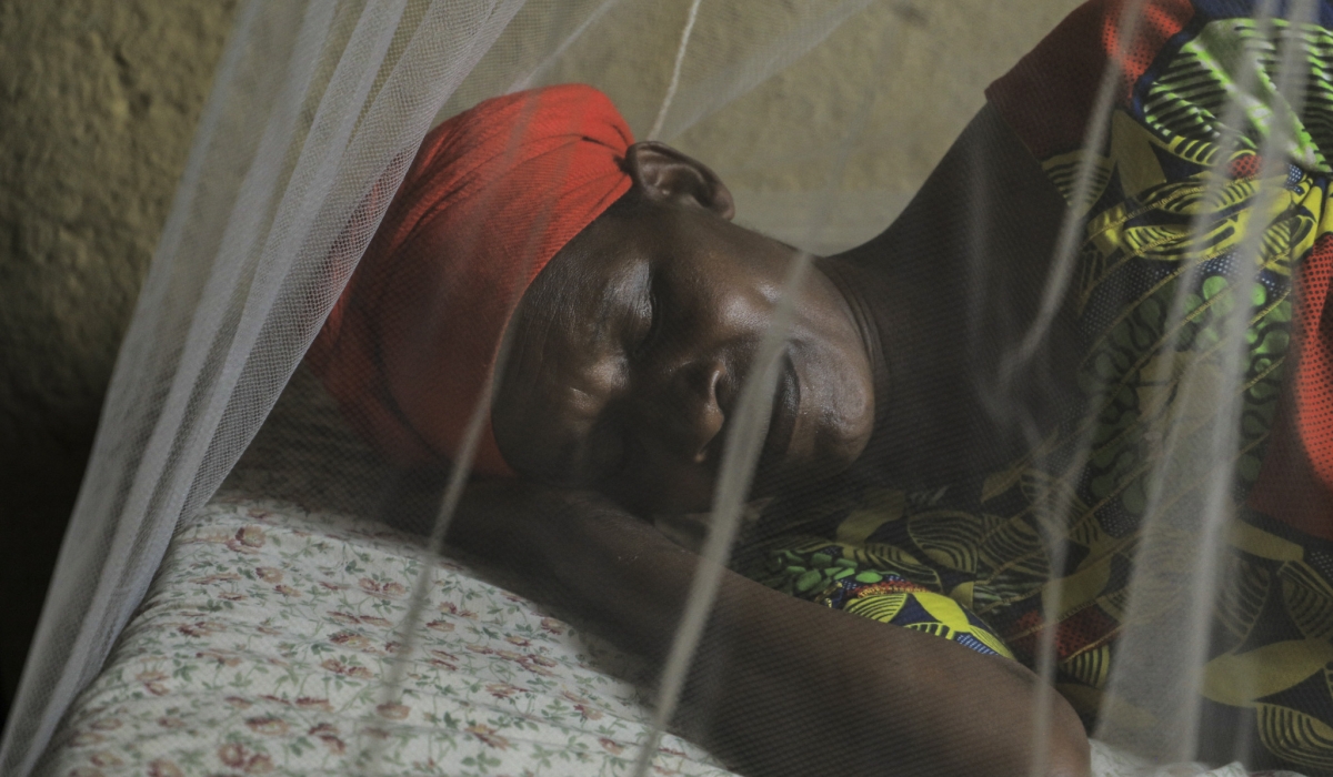 A women sleeping in mosquito net as a way to prevent Malaria in her family. Photo by Craish Bahizi