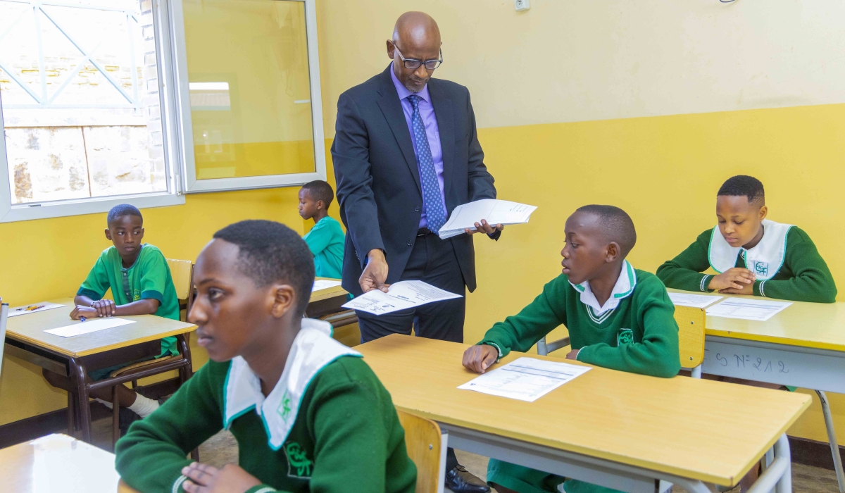 Minister Education Joseph Nsengimana distributes exam copies to the candidates at the launch on Monday, June 30. Courtesy