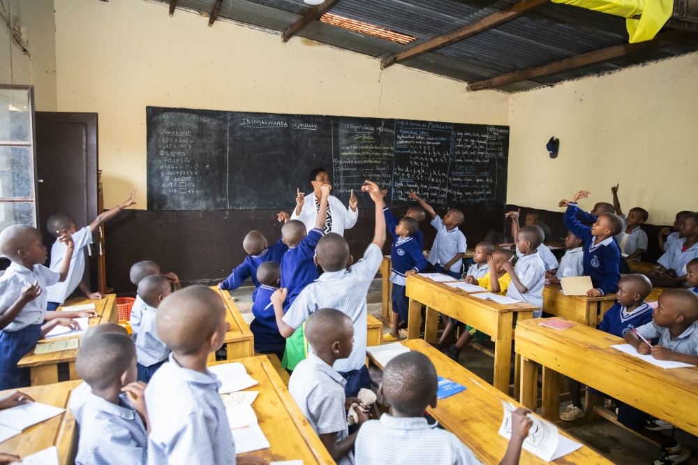 A teacher engages pupils at Muhima Primary School in Nyarugenge District. Ongoing education reforms aim to tackle persistent challenges in the system, such as overcrowded classrooms. Photo by Craish Bahizi.