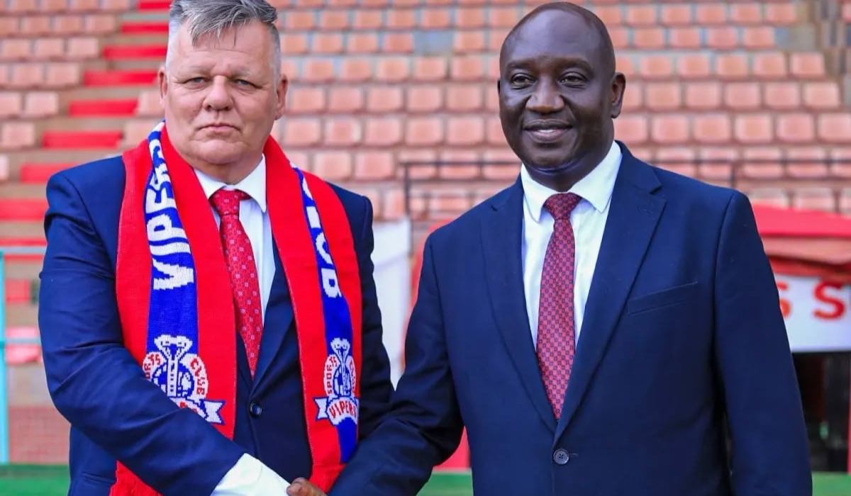 Minnaert shakes hands with Vipers SC president Lawrence Mulindwa during his unveiling.