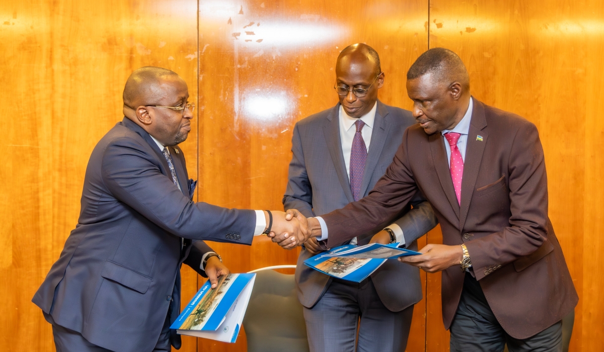 The two countries&#039; diplomats shake hands after the signing of the deal as a UNHCR official looks on.