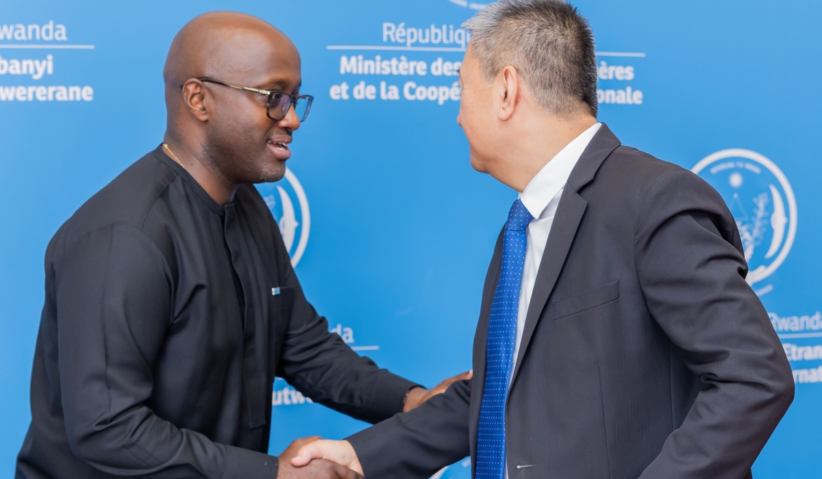 Nduhungirehe (left) shakes hands with Huang during their meeting on Thursday.