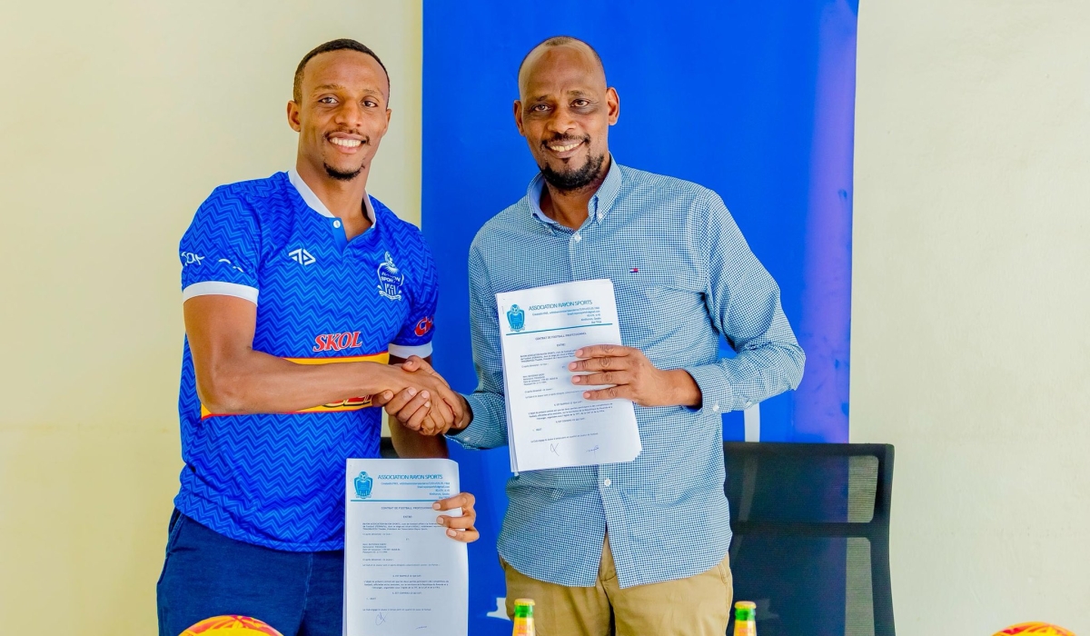 Emery Bayisenge shakes hands with Rayon Sports President Thaddée Twagirayezu after signing a one-year contract. Courtesy photo