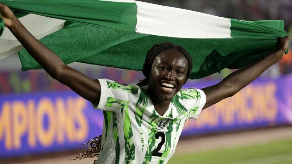 Nigeria&#039;s midfielder Rinsola Babajide celebrates with a national flag after the 2025 WAFCON final win against Morocco. The Super Falcons received many rewards back home from their government.