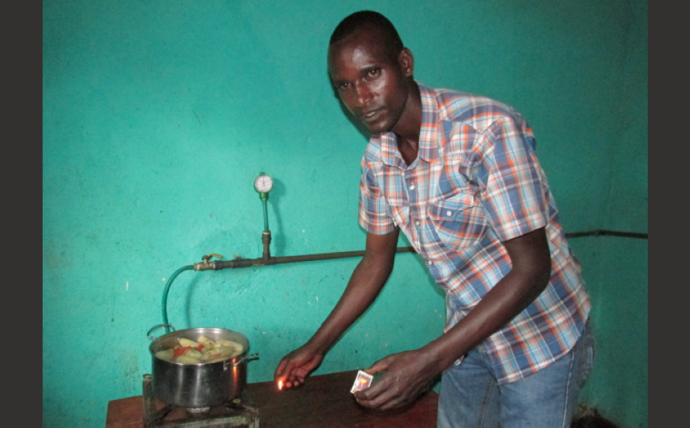 A resident using Biogas to cook his food in Gisagara District. Courtesy