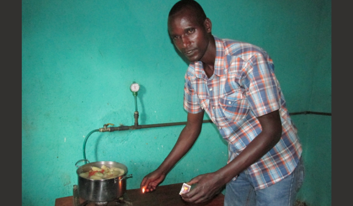 A resident using Biogas to cook his food in Gisagara District. Courtesy
