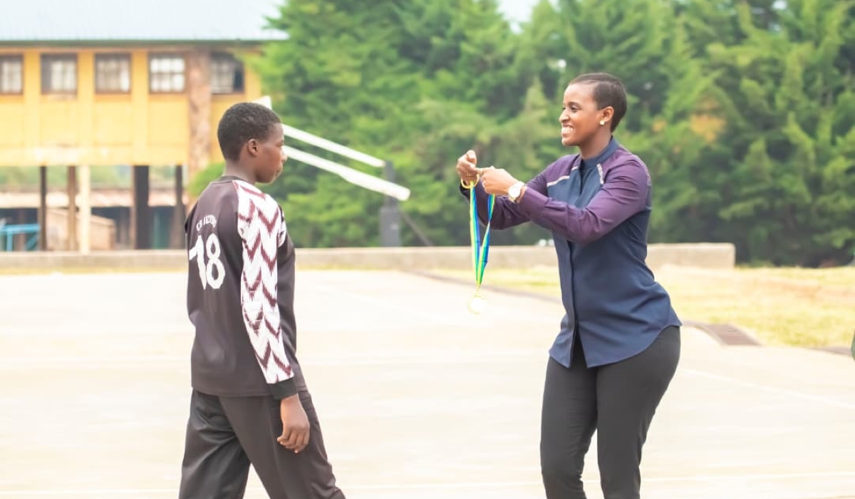 Minister of Sports Nelly Mukazayire hands over a medal to one of the best performing athletes at AFD-Isonga camp that concluded in Huye on Saturday, August 9-courtesy photos