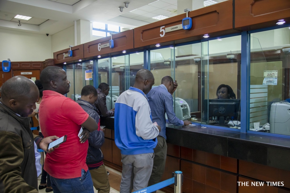 Bank tellers attend to customers at Bank of Kigali main branch. Craish BAHIZI