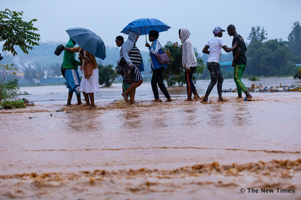 Kigali residents wade through a flooded street in Kigali. According to Meteo Rwanda, dry weather conditions with sunny intervals during the day are expected to prevail across the country in the last ten days of August. File