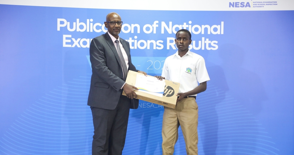 Minister of Education Joseph Nsengimana awards the O-Level overall best performer Tresor Henock Izere, a student at Es EFOTEC Kanombe. Photo by CRAISH Bahizi