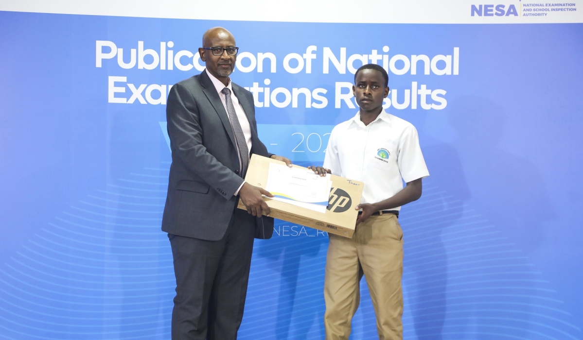 Minister of Education Joseph Nsengimana awards the O-Level overall best performer Tresor Henock Izere, a student at Es EFOTEC Kanombe. Photo by CRAISH Bahizi