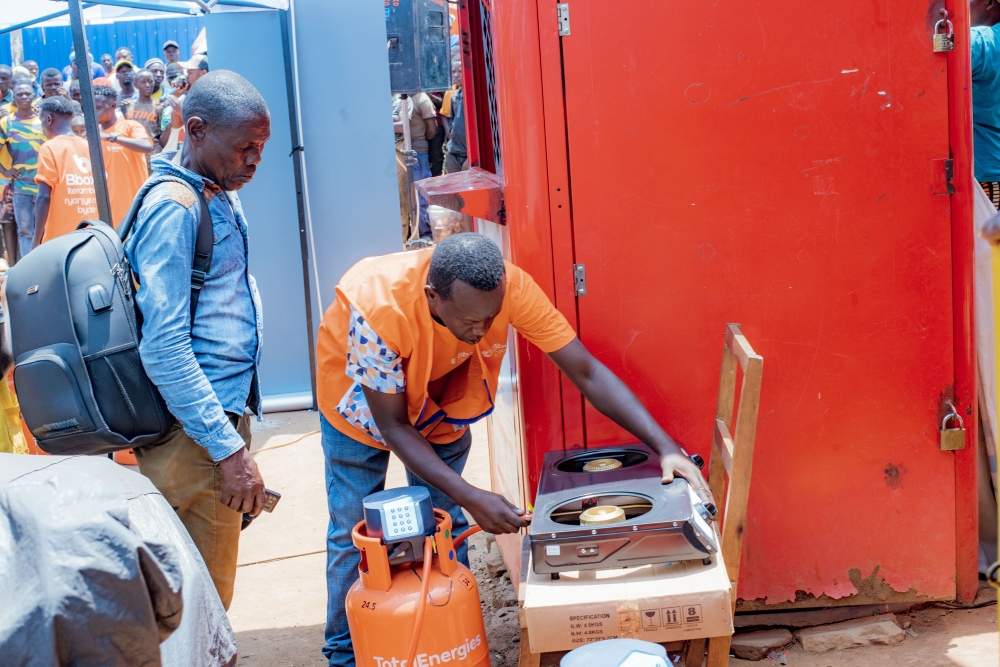 A Bboxx sales agent demonstrates how to safely connect a gas canister to a cooker. During market storming activities, customer education and safety remain top priorities.