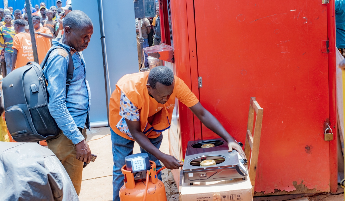 A Bboxx sales agent demonstrates how to safely connect a gas canister to a cooker. During market storming activities, customer education and safety remain top priorities.