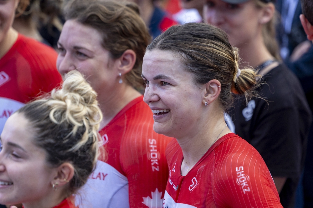 Magdeleine Vallieres&#039; teammates smile as he steps onto the podium to receive the award.