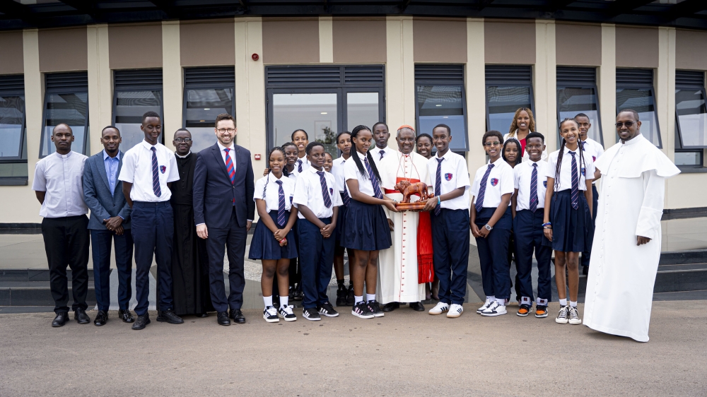 Cardinal Kambanda poses for a photo with students and officials during his visit on Wednesday. Photos by Kellya Keza