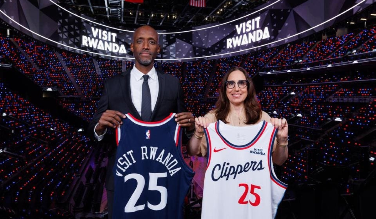 Rwanda Development Board CEO, Jean Guy Afrika, poses with an LA Clippers representative while holding Los Angeles Clippers jerseys branded with the “Visit Rwanda” logo during the official partnership announcement.