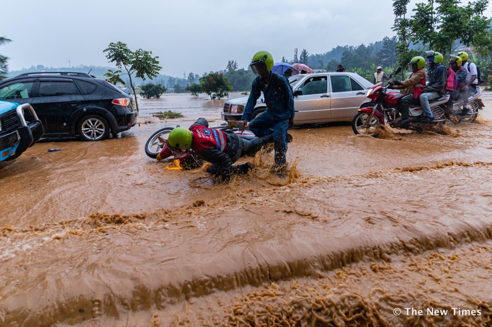 Vehicles and pedestrians wade through a flooded street in Gisozi, Kigali, on January 28, 2020. The government is rehabilitating the wetland to mitigate flooding in the area. File