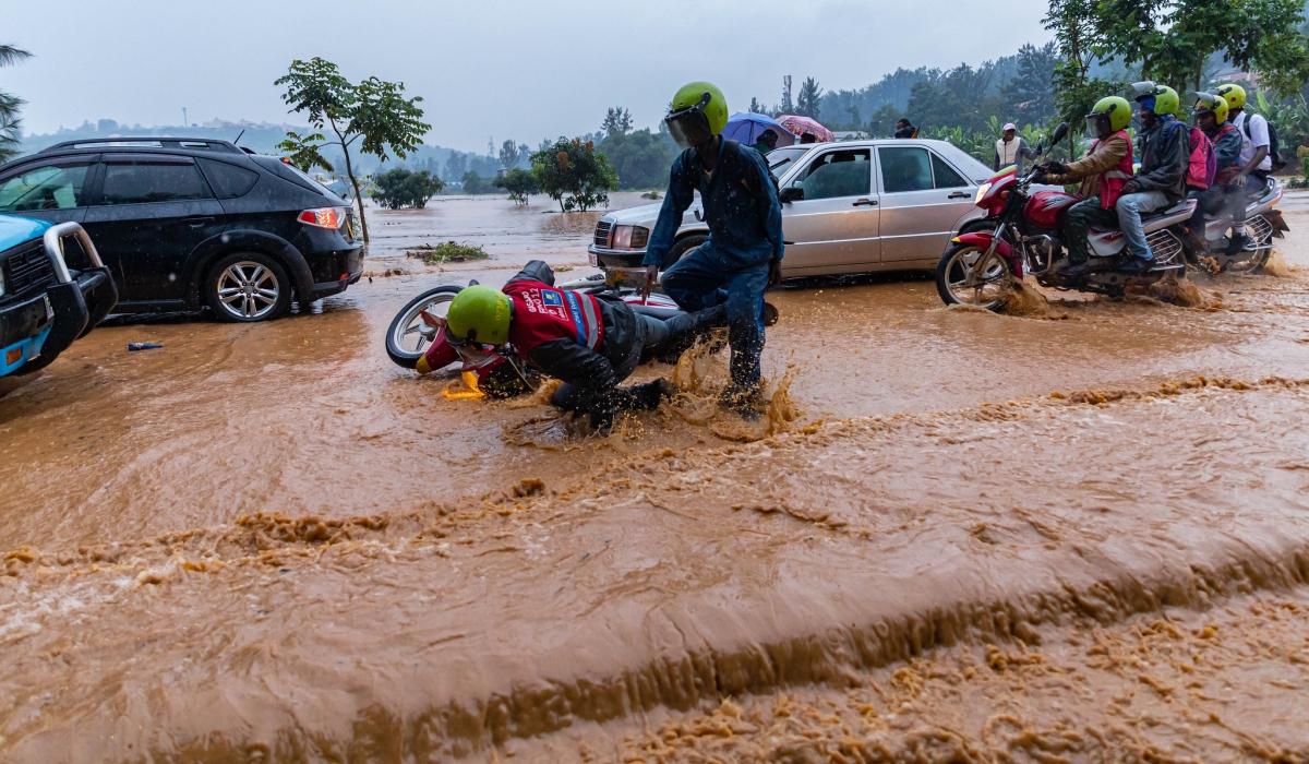 Vehicles and pedestrians wade through a flooded street in Gisozi, Kigali, on January 28, 2020. The government is rehabilitating the wetland to mitigate flooding in the area. File