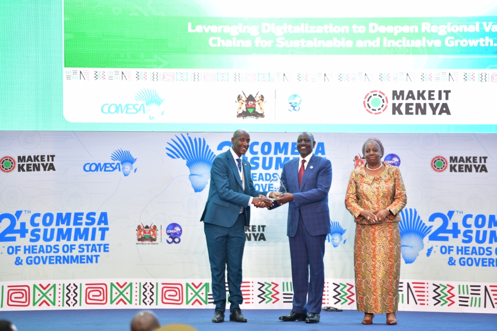 Gashegu Muramira receives the COMESA Media Excellence Award from Kenyan President and incoming COMESA Chairperson William Ruto, as COMESA Secretary General, Chileshe Mpundu Kapwepwe, looks on. Courtesy