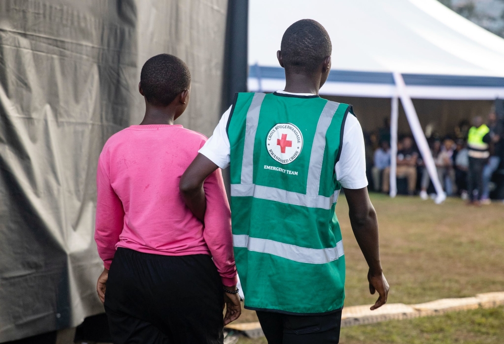 A volunteer helps a trauma victim during a commemoration event at Kicukiro Nyanza Genocide Memorial on April 11. Photo by Dan GATSINZI