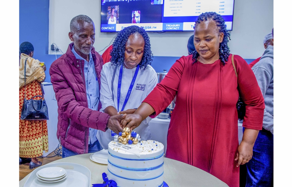 Anita Umuhire, the Chief Financial Officer of Bank of Kigali, cuts a cake with BK customers  during the Customer Service Week celebration at the headquarters on Friday, October 10. All photos by Craish Bahizi