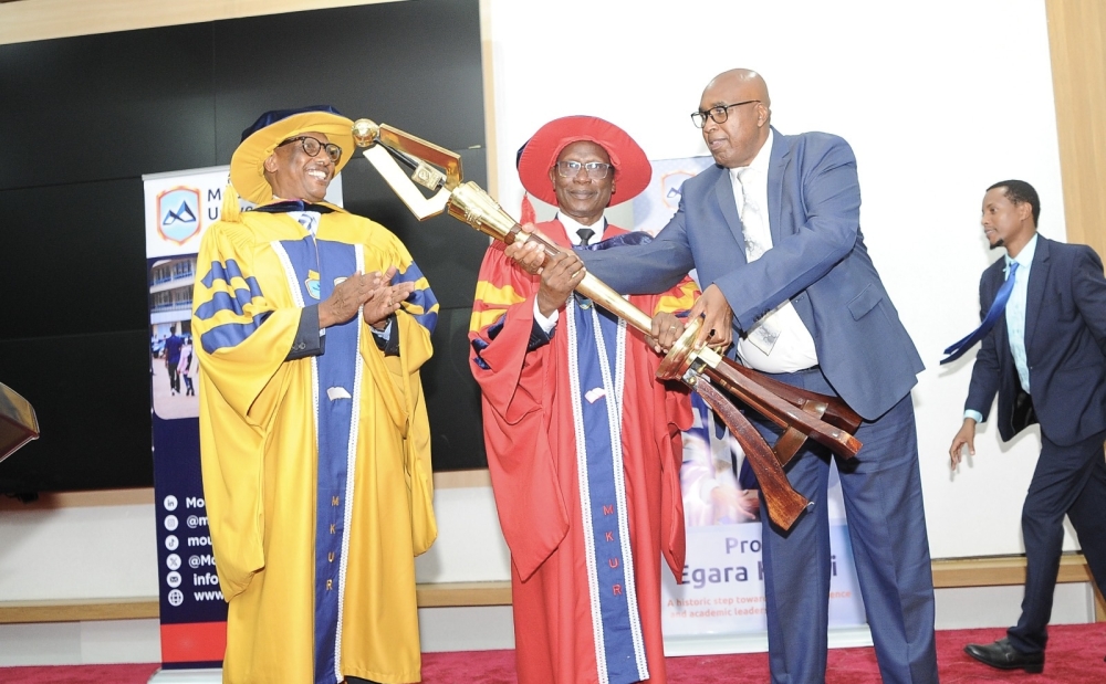 Prof. Simon Gicharu (right) hands over the Mace, one of the instruments of authority, to Prof. Egara Kabaji. Looking on is Dr Innocent Mugisha (left) Chairman , University Governing Body.