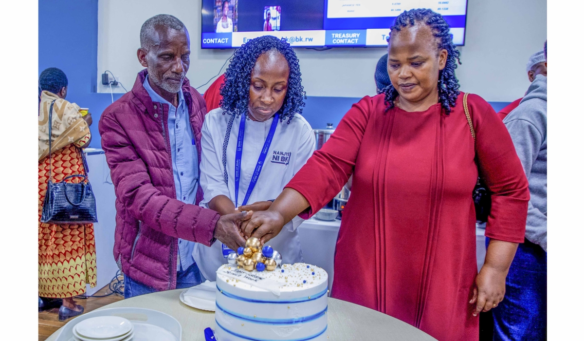 Anita Umuhire, the Chief Financial Officer of Bank of Kigali, cuts a cake with BK customers  during the Customer Service Week celebration at the headquarters on Friday, October 10. All photos by Craish Bahizi