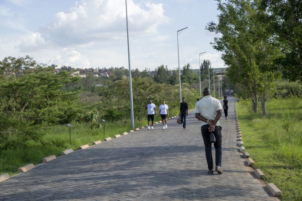Visitors enjoying a peaceful walk along the green pathways of Nyandungu.