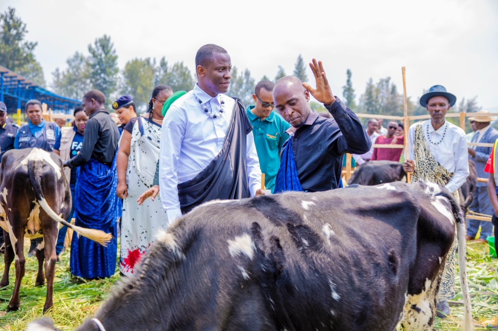 Dominique Habimana, Minister of Local Government gives a cow to a resident through Girinka Programme in Musanze on Friday, August 1. Courtesy