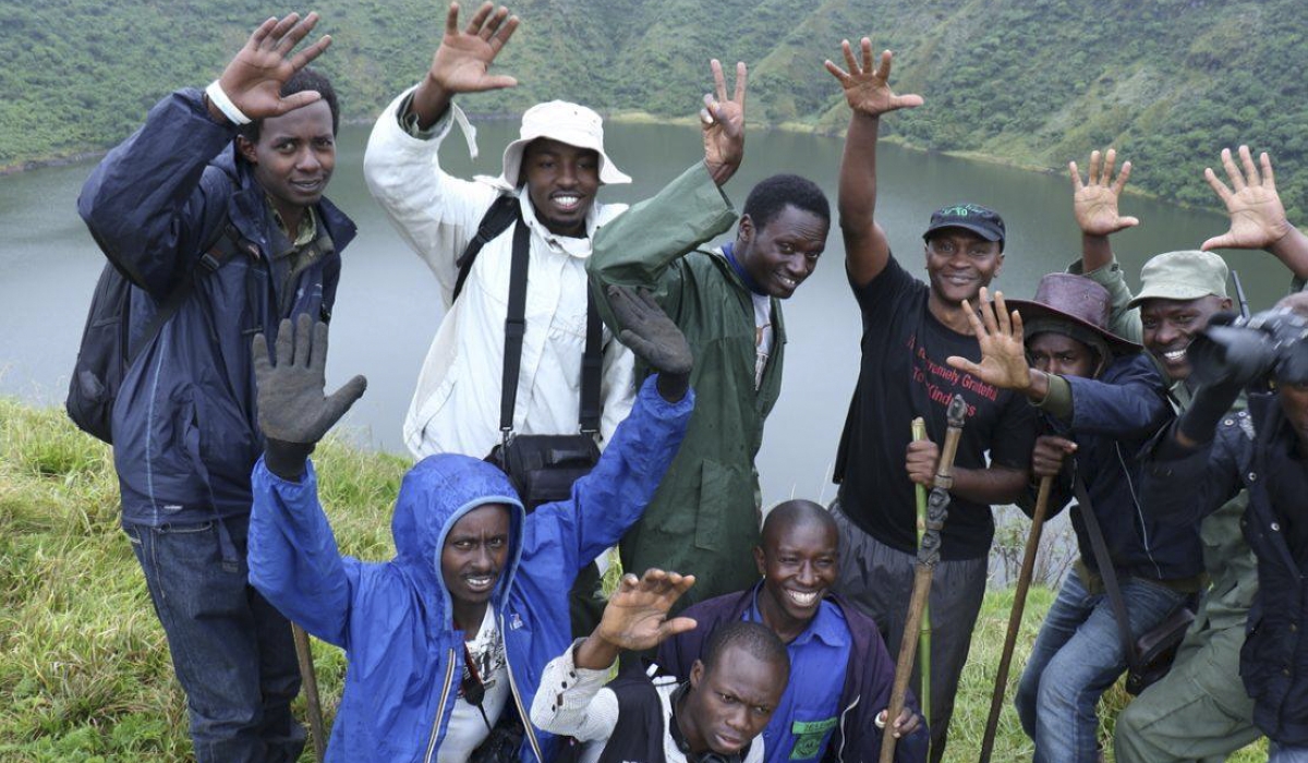 Visitors celebrate at the top of Bisoke mount in Volcanoes National Park. Photo by Sam Ngendahimana