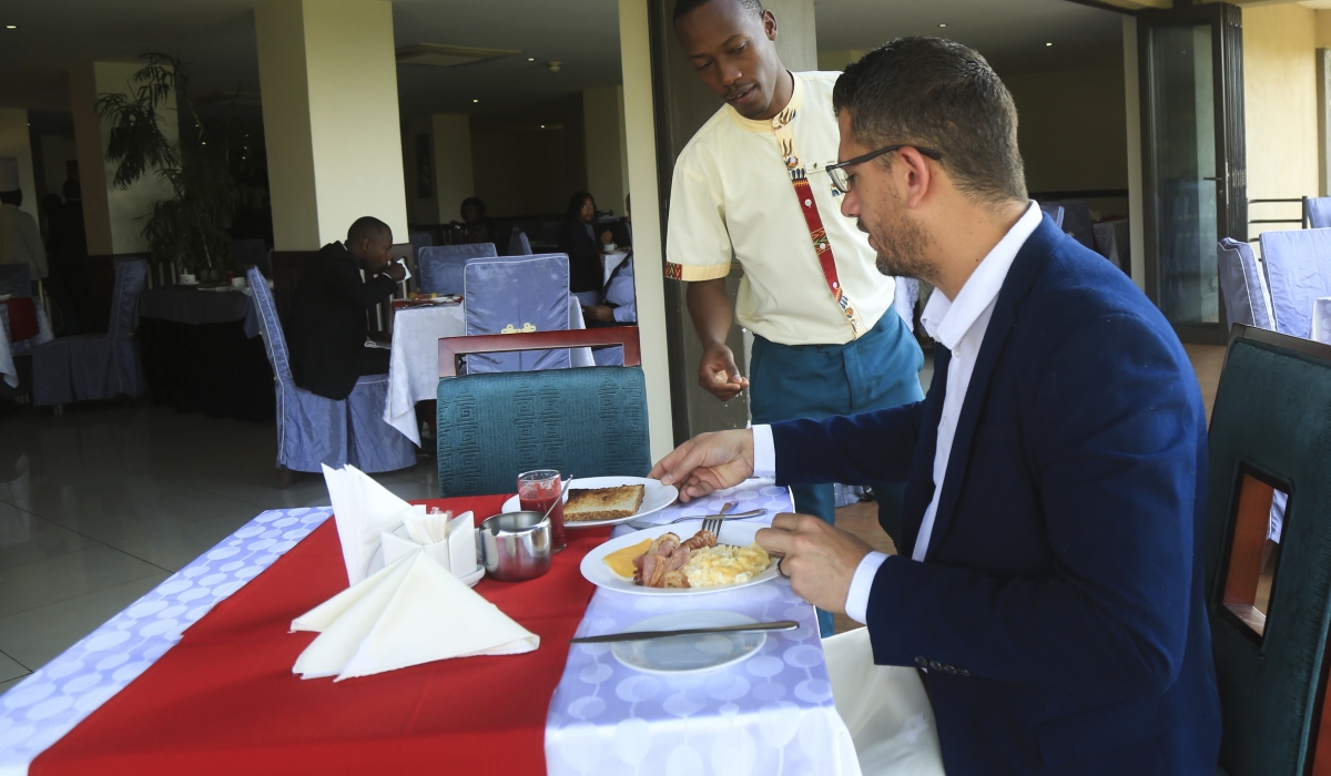 A waiter attends to a client at Portofino Hotel in Kigali. Photo by Sam Ngendahimana.