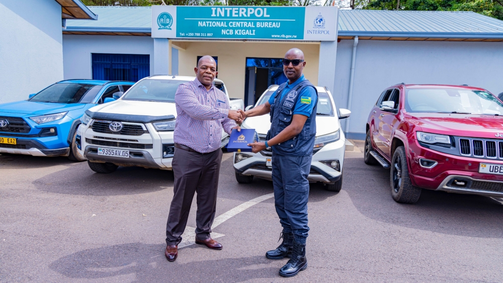 Rwanda Investigation Bureau&#039;s Antoine Ngarambe, Head of the INTERPOL National Central Bureau Kigali and International Cooperation Department, hands over the stolen cars to  the South African Police Service representative  Lt. Col. Brian Butana Mashingo, Group Commander for   International Vehicle Crime Investigations, in Kigali on Saturday, October 25. Courtesy