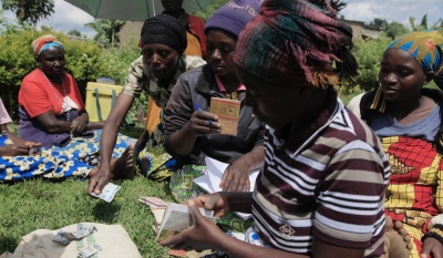 Women collect their savings during a cooperative meeting in Musanze District. Photo by Sam Ngendahimana.