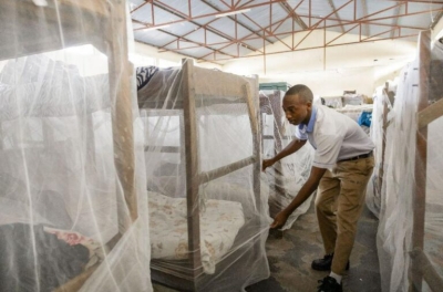 A student carefully arranges a mosquito net on his bed before heading to class. The country has recorded more than 91,000 malaria cases, with 87 percent concentrated in 15 districts. Courtesy
