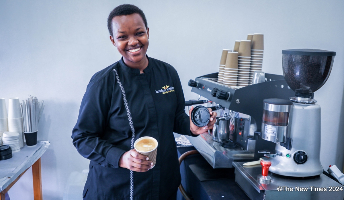 A barista smiles as she prepares a cup of coffee at Bourbon Coffee in Kigali. Photo by Craish Bahizi.