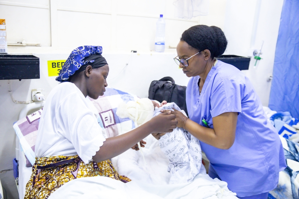 A nurse assists a mother with her newborn at a hospital in Kigali on January 1, 2025. Photo by Emmanuel Dushimimana.