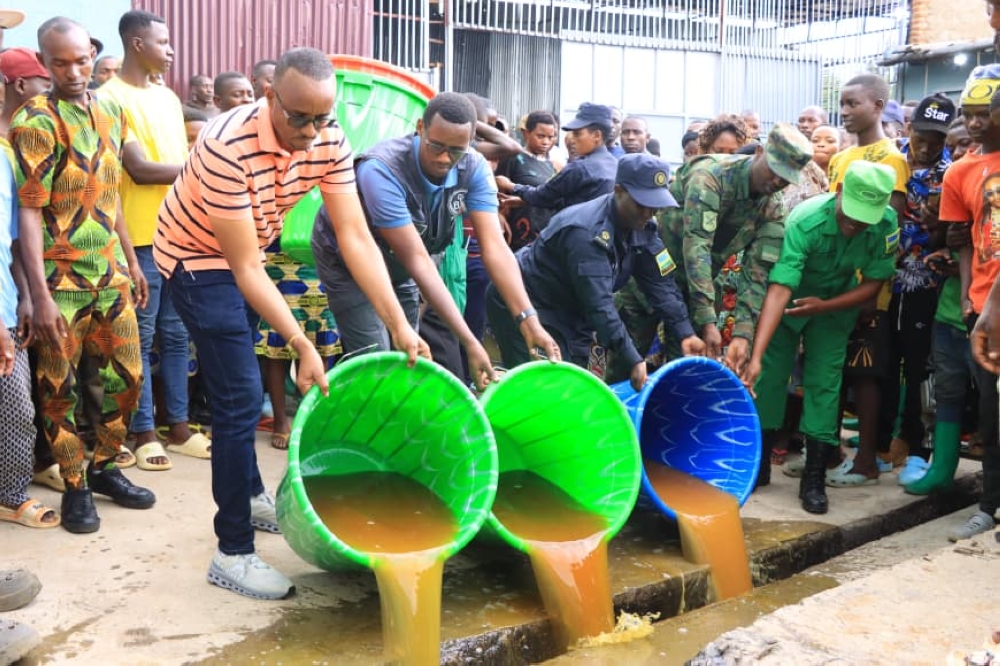 Mayor of Bugesera District, Richard Mutabazi, and security officers during a crackdown on illegal production of alcoholic drinks where they  destroyed more than 74,000 litres in one day. Courtesy