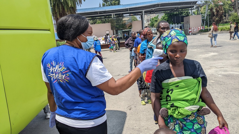 The returnees having their temperature checked after crossing into Rwanda on Thursday. Photo by Germain Nsanzimana.